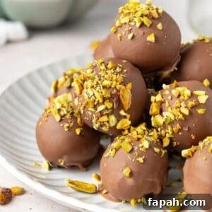 Decadent Pistachio Truffle Recipe — No-Bake Chocolate Pistachios 14 Round grey plate topped with Pistachio Truffles.