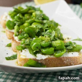 4 broad bean crostini on a rectangular white plate with a checked cloth underneath