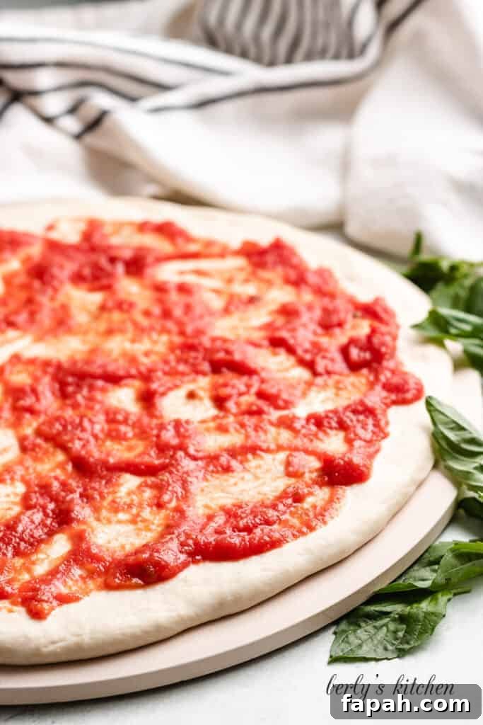 Marinara sauce has been spread over the dough.