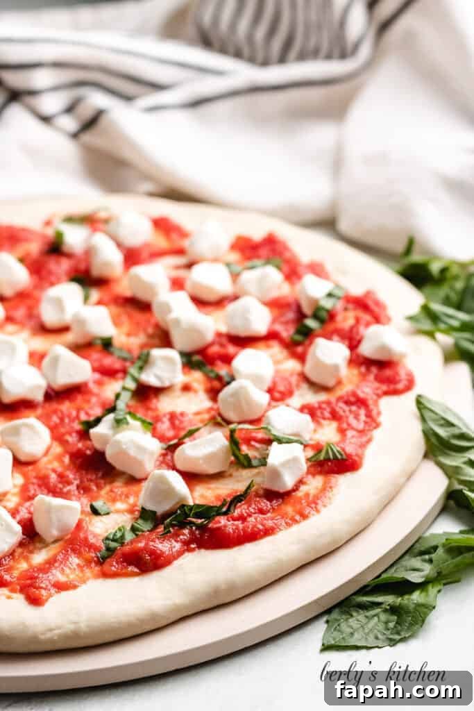 Thinly sliced fresh basil leaves added to the pizza.