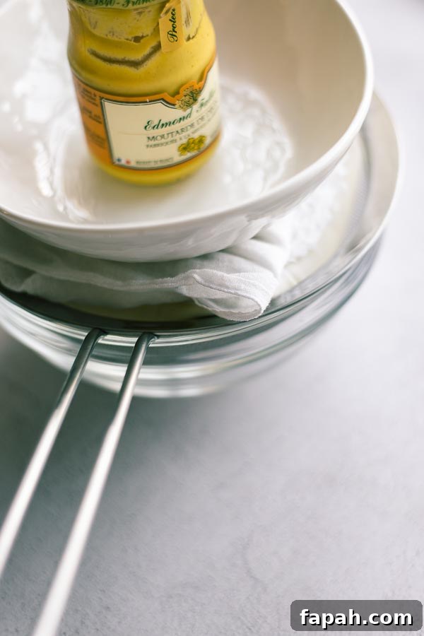 Using a weight to speed up the whey draining process when making yoghurt cheese at home.