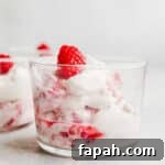 Whipped cream and raspberries in a glass.