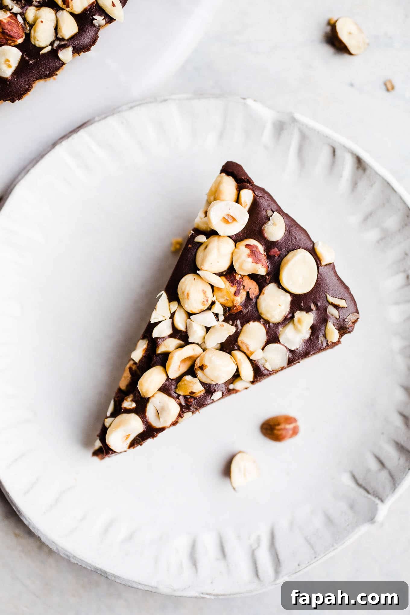 35 Gluten-Free Valentine’s Day Desserts to Delight Your Loved One 16 A slice of hazelnut chocolate tart on a white plate.