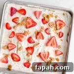 35 Gluten-Free Valentine’s Day Desserts to Delight Your Loved One 10 An icebox cake in a baking pan topped with strawberries and graham cracker crumbs.
