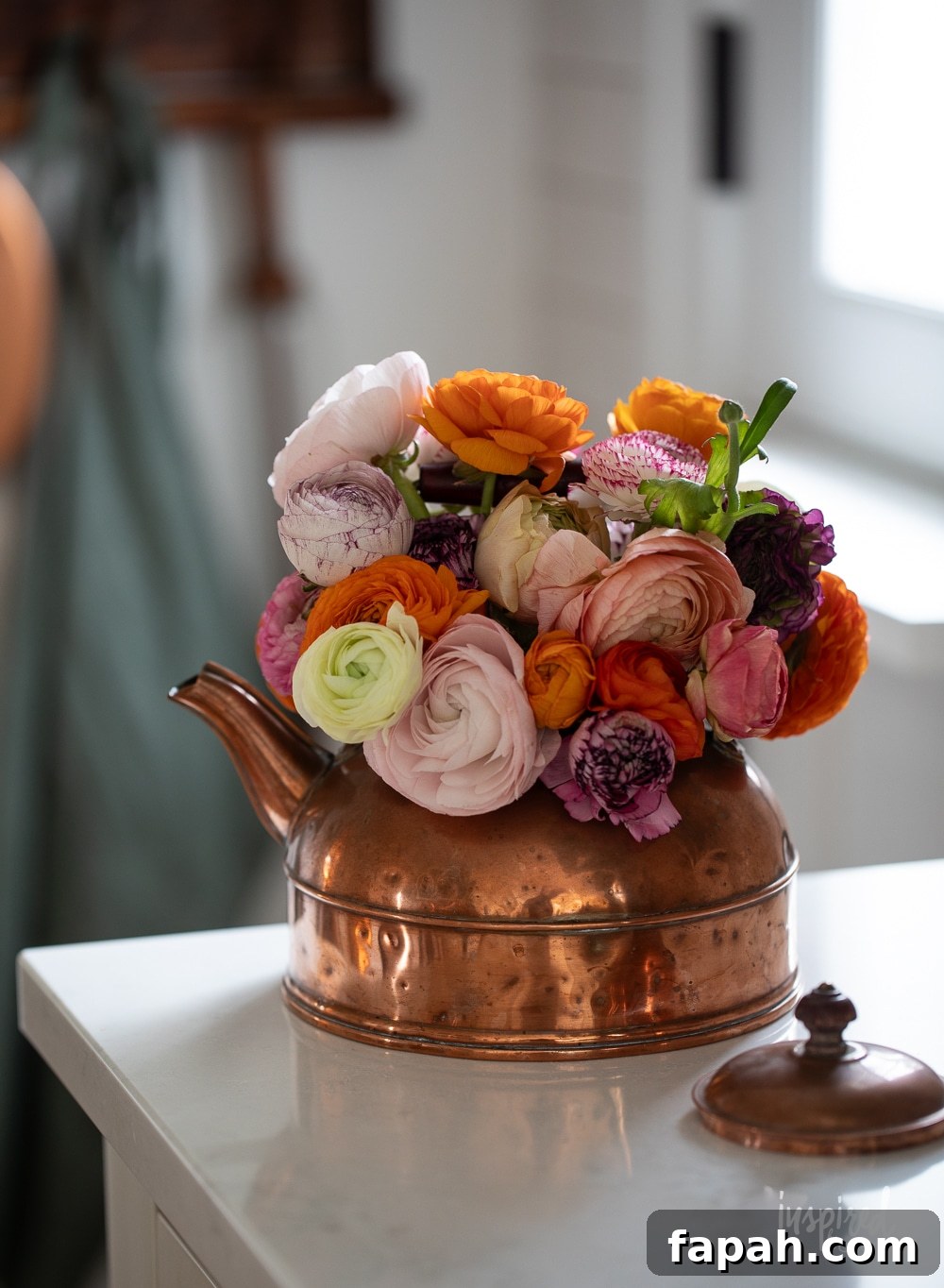 Complete Guide to Flower Arranging: Techniques, Tips & Styles 17 copper teapot filled with colorful ranunculus flowers.