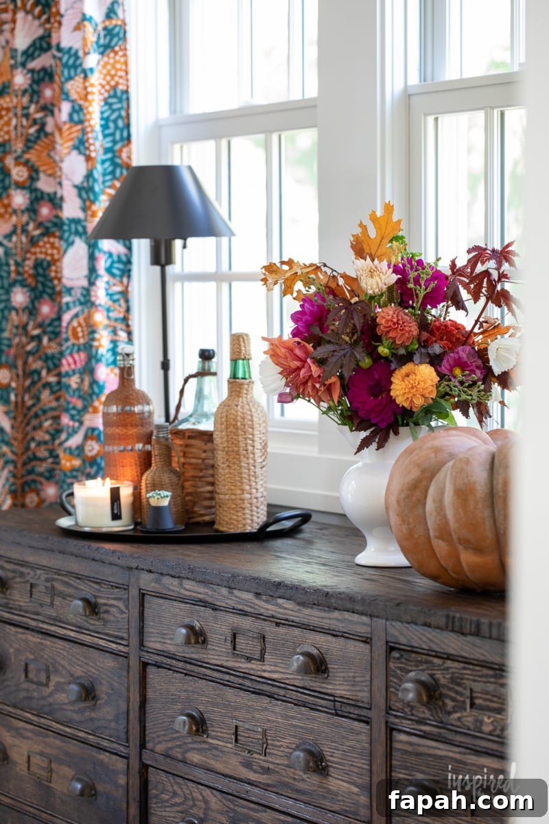 Complete Guide to Flower Arranging: Techniques, Tips & Styles 19 fall flower arrangement with pumpkins on a sideboard.