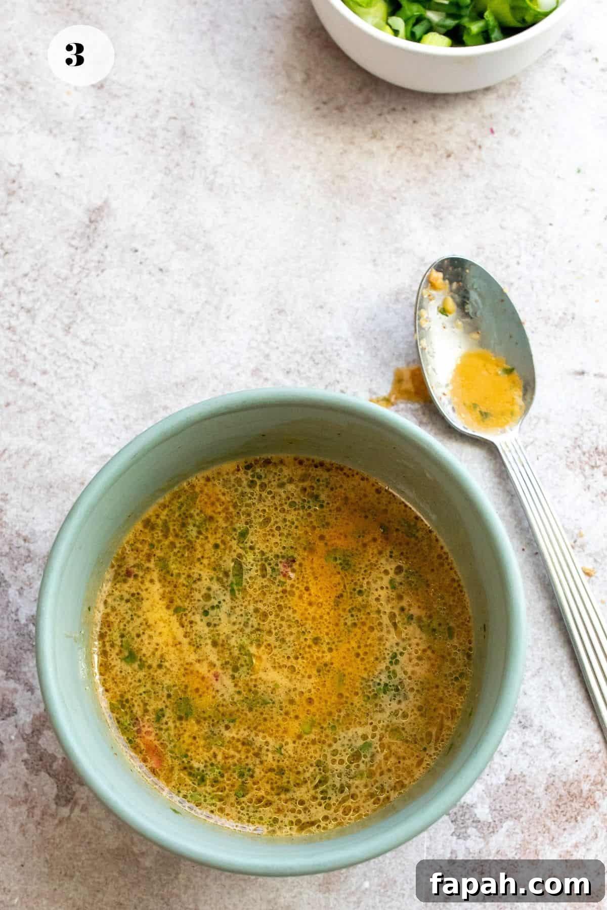 Dressing in a bowl with a spoon to the side. 
