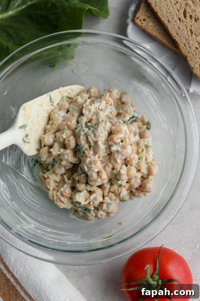 Vegan Chickpea Salad Sandwich ingredients mixed in bowl with spatula