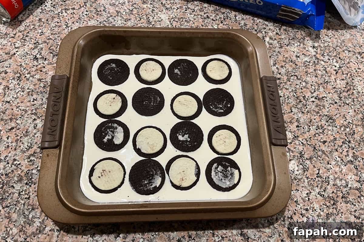 Baking pan with cream in it along with 8 disassembled cookies.