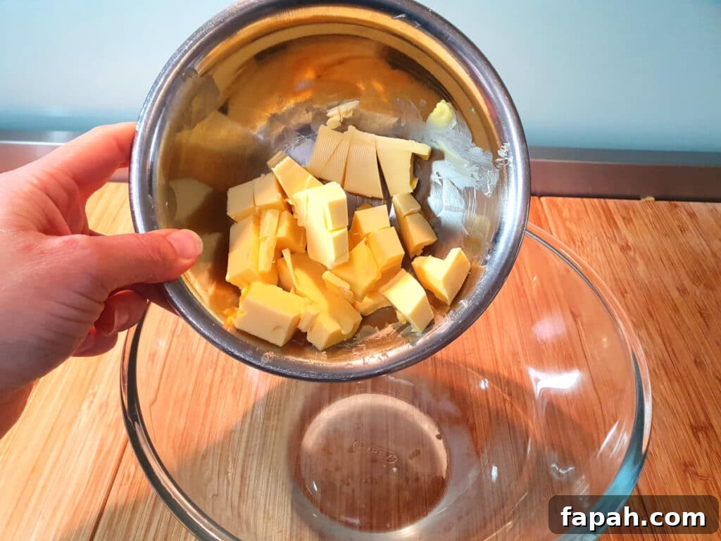 How to Make Homemade Oreo Cookies from Scratch 19 adding chopped room temperature butter to glass mixing bowl.