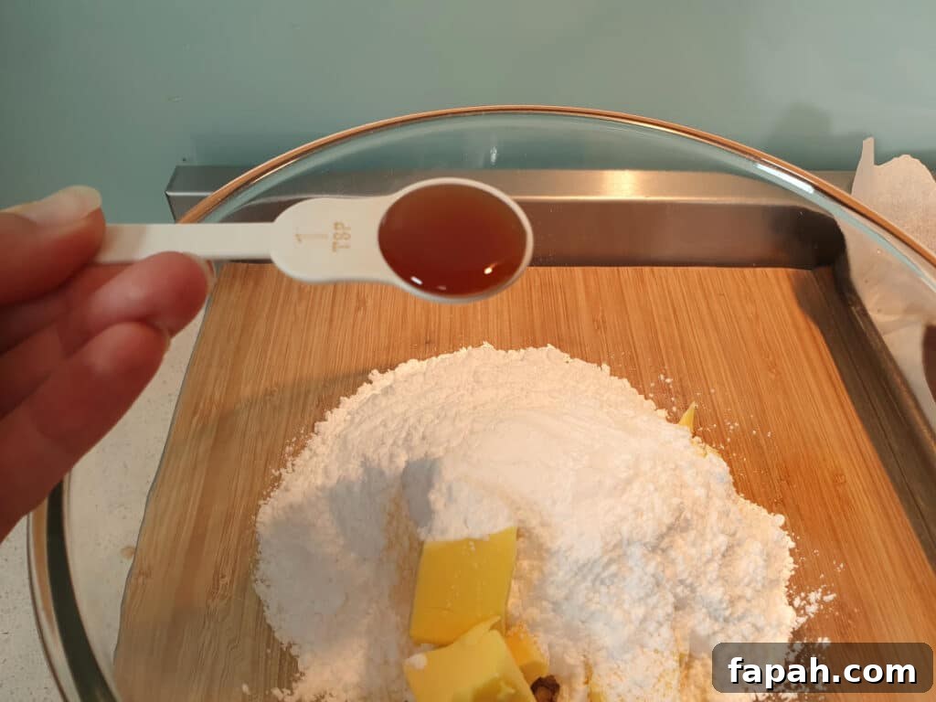How to Make Homemade Oreo Cookies from Scratch 21 adding vanilla to glass mixing bowl with butter and icing sugar.