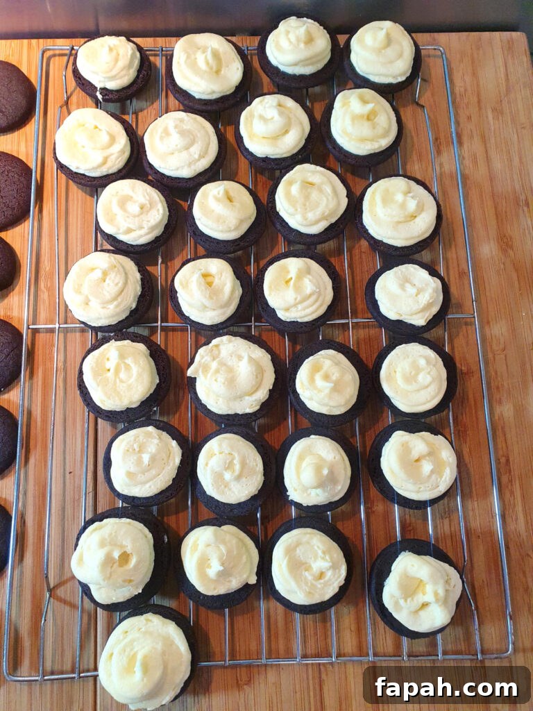 How to Make Homemade Oreo Cookies from Scratch 26 top down view cookies with vanilla filling on a wire rack, ready for cookies to place on top.