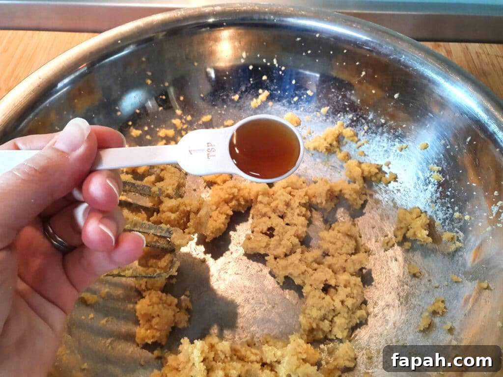 How to Make Homemade Oreo Cookies from Scratch 7 adding vanilla to beaten white and brown sugar and butter, in a large metal mixing bowl.
