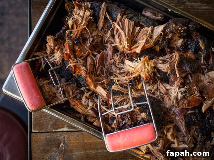 Smoked Pulled Pork Recipe: Succulent Barbecue Shredded Pork Butt 5 shredded pulled pork butt in aluminum pan with meat shredders
