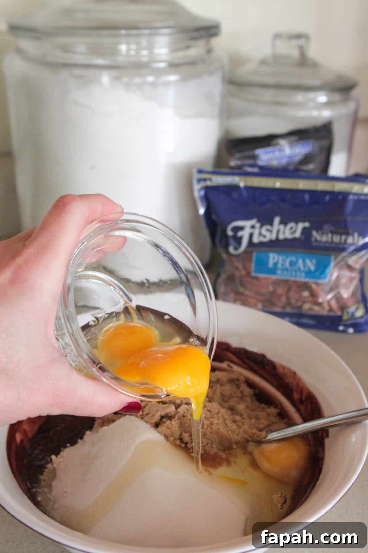 Decadent Caramel Pecan Brownies with Gooey Center 3 pouring eggs in brownie mixing bowl