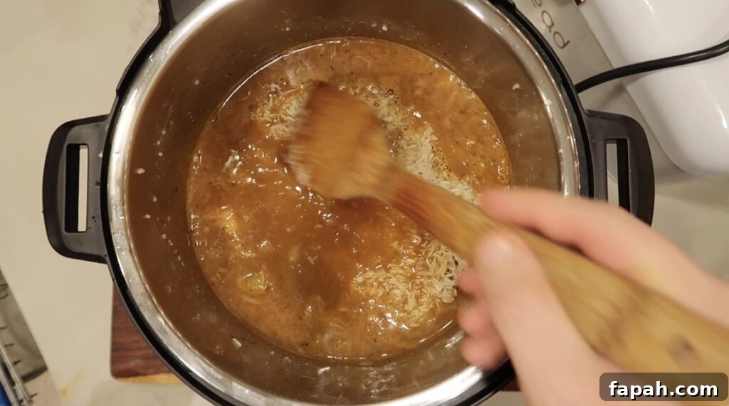 Smoothing rice down into seasoned broth