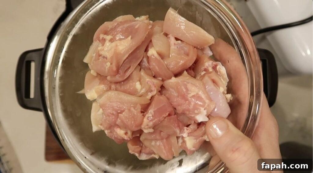 Adding diced boneless, skinless chicken thighs and/or breasts to the pot.