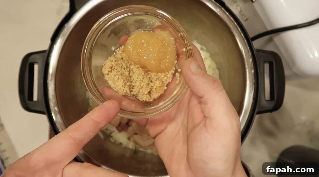 Adding crushed ginger and garlic to the pot