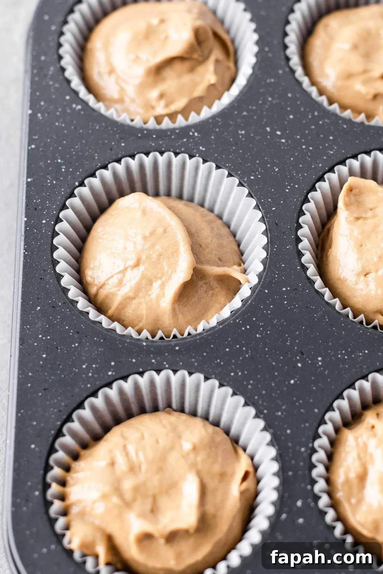 tiramisu cupcake batter portioned into cupcake cups