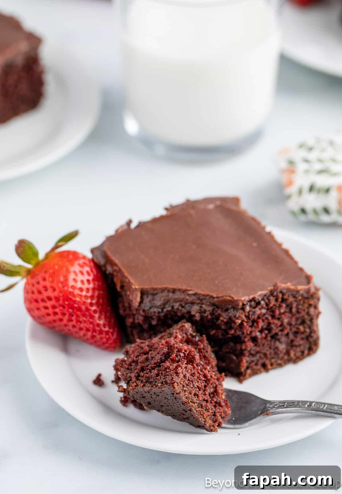 Moist Buttermilk Chocolate Cake Recipe for Rich Chocolate Flavor 13 A white plate with chocolate cake with a smooth chocolate frosting.