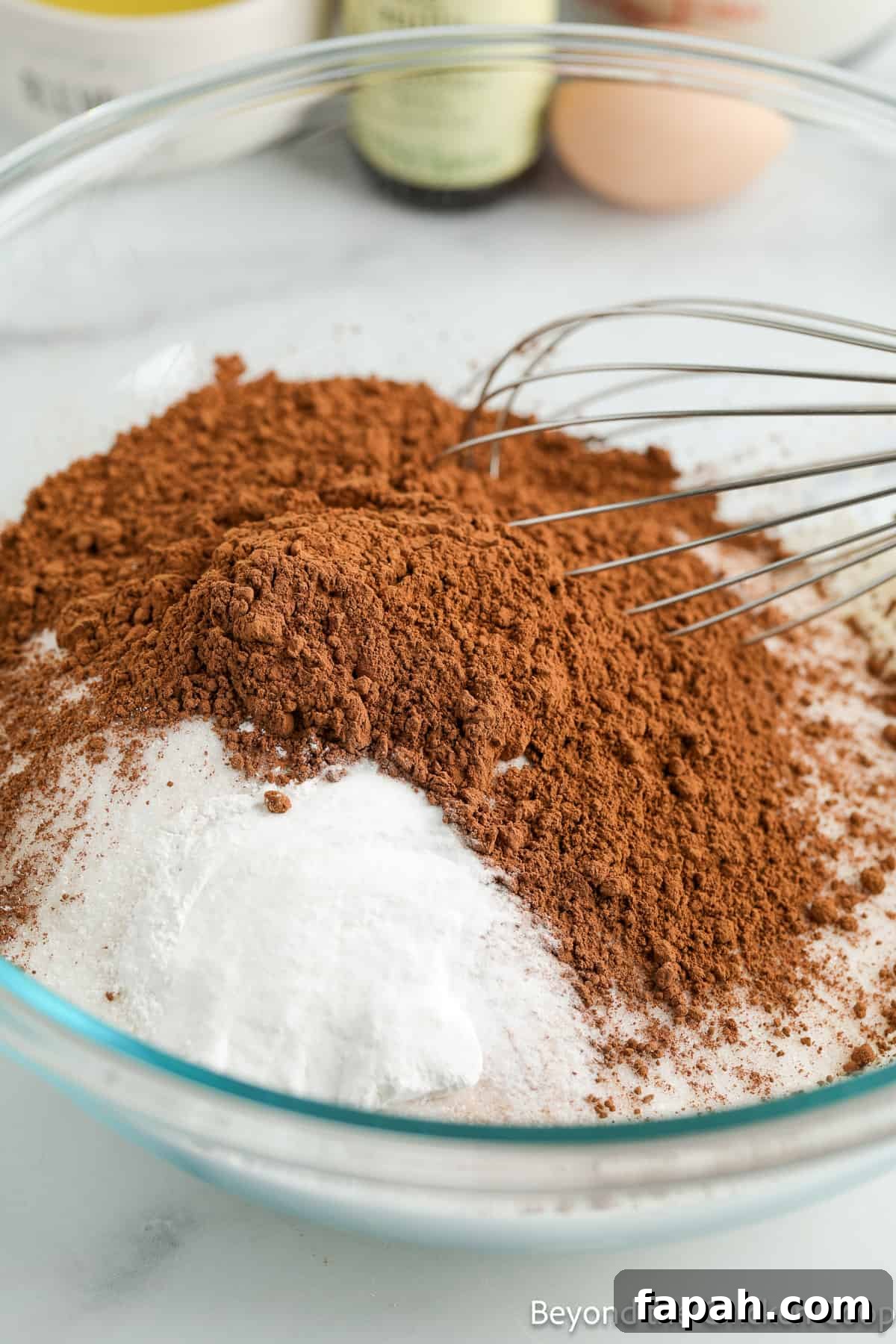 Moist Buttermilk Chocolate Cake Recipe for Rich Chocolate Flavor 4 Flour and cocoa powder in a glass bowl with a whisk.