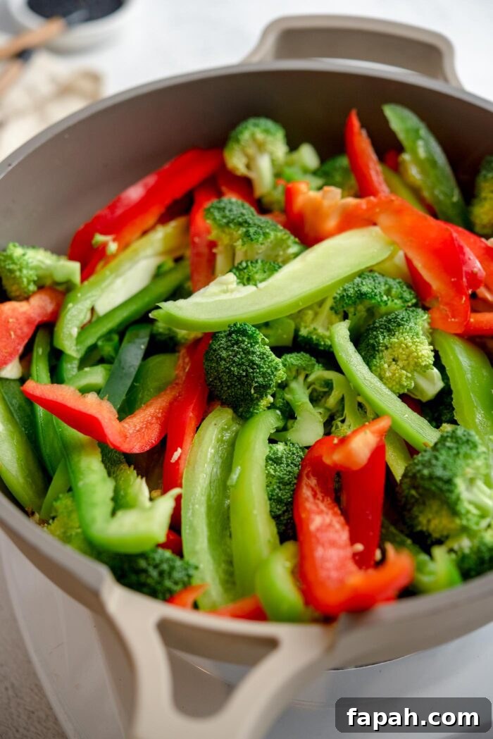 Crispy Orange Tofu Stir-Fry with Tangy Citrus Glaze 6 Bell pepper, green onion and broccoli cooking in a large skillet.