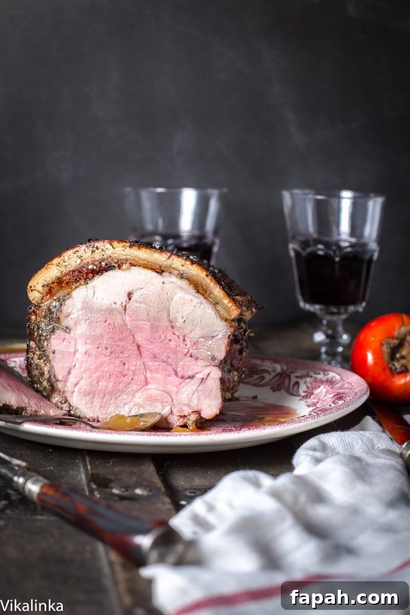 Pork roast cut open next to two glasses of wine