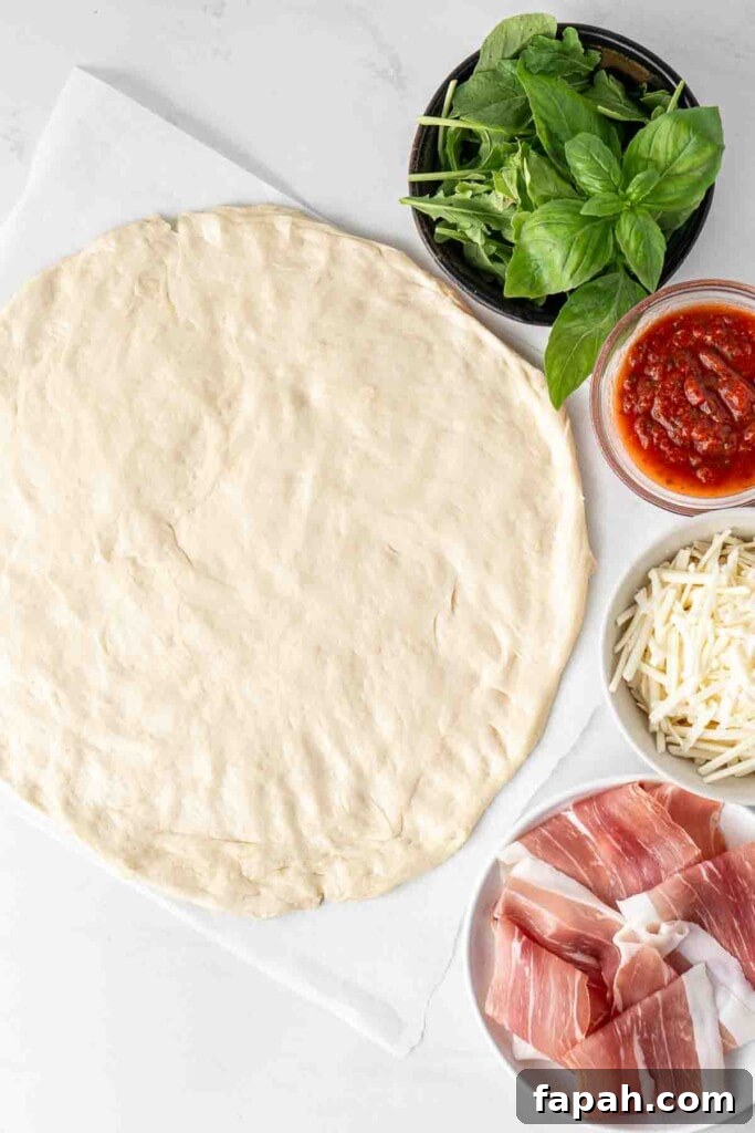 Pizza dough rolled out with all toppings on the side.