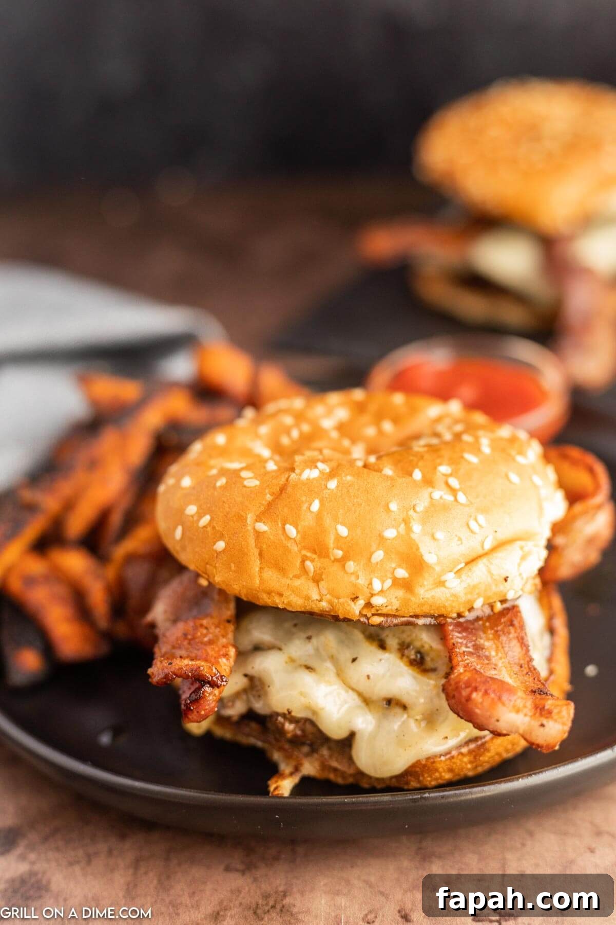 Bacon Cheeseburger on a plate with sweet potato fries.