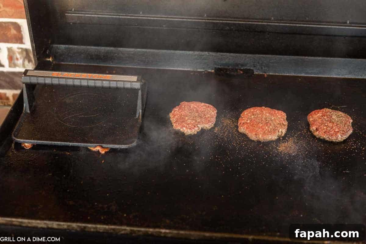 Cooking burgers on the griddle with a burger press.