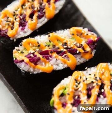close up shot of 3 sushi sandwiches on serving plate