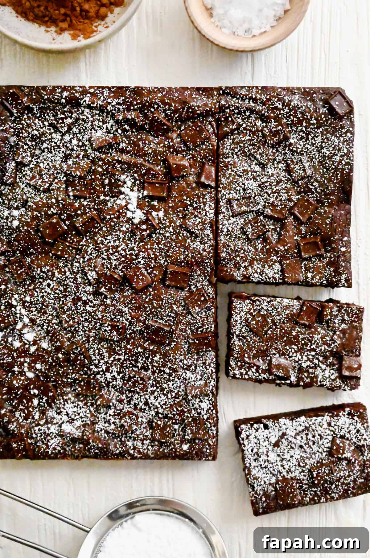 Fudgy Cocoa Brownies Recipe: Rich, Chewy Homemade Treat 2 Homemade brownies studded with chocolate chunks dusted with powdered sugar.