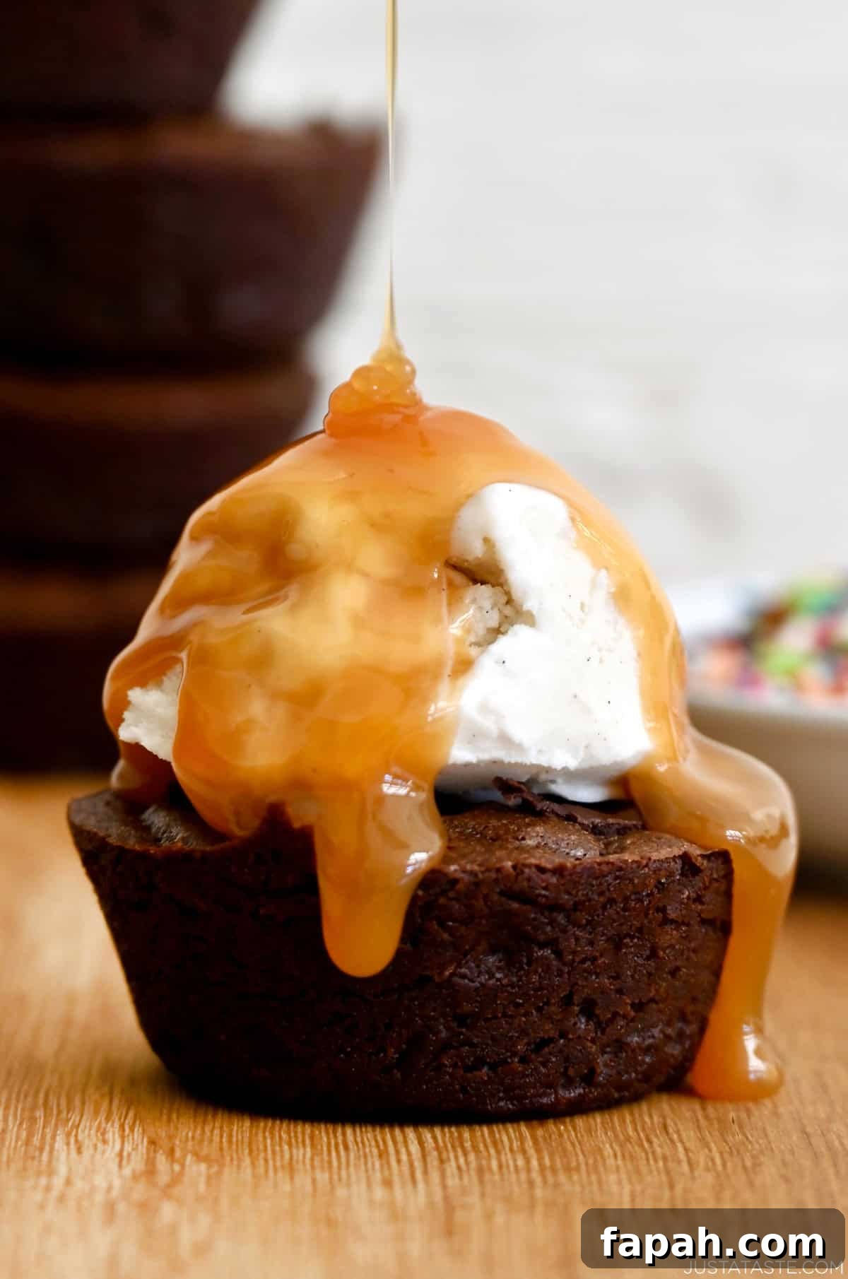 Fudgy Cocoa Brownies Recipe: Rich, Chewy Homemade Treat 9 A fudge brownie cupcake topped with vanilla ice cream and a drizzle of caramel sauce.