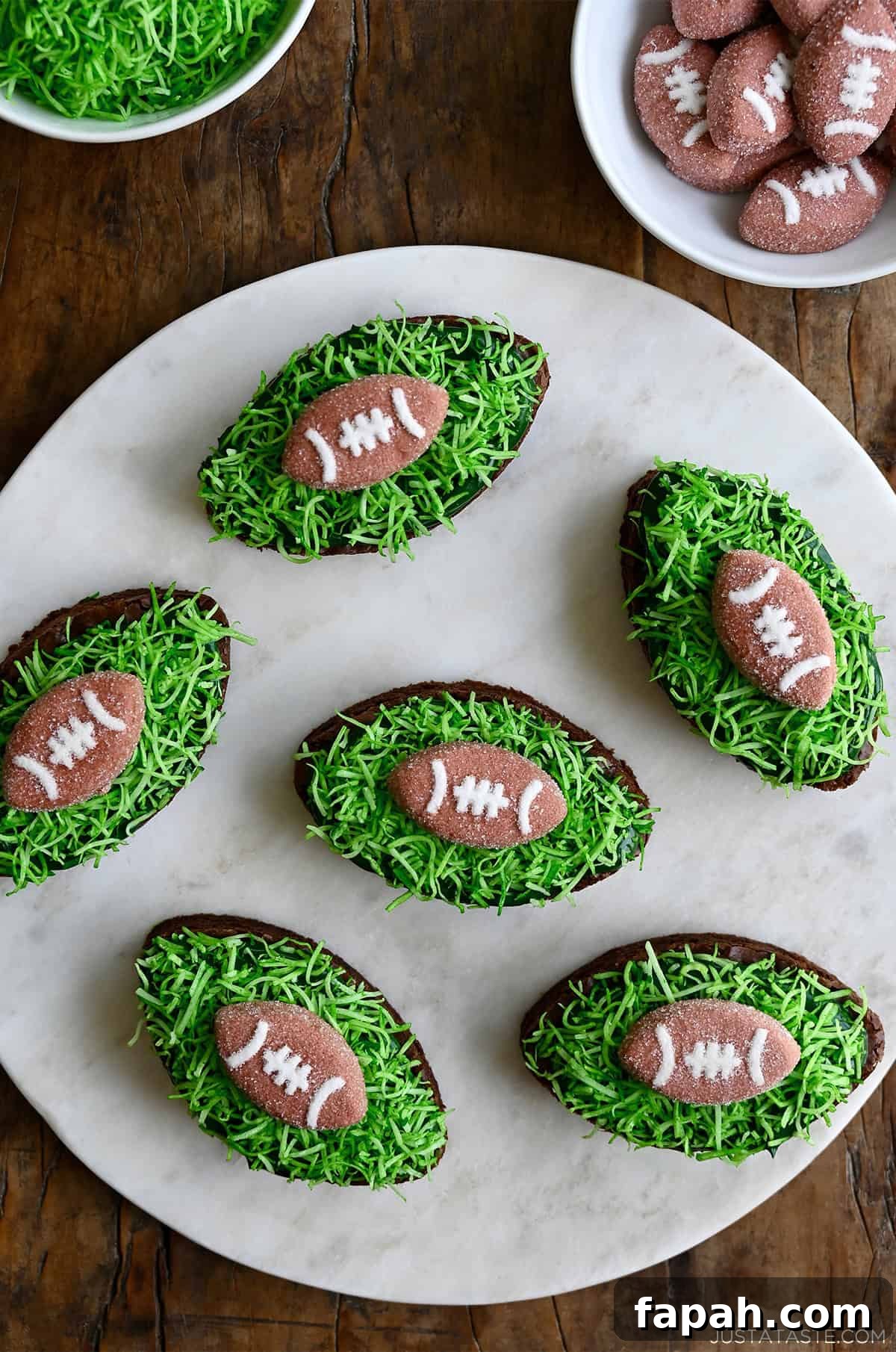 Fudgy Cocoa Brownies Recipe: Rich, Chewy Homemade Treat 10 Football-shaped brownies topped with green frosting and football marshmallows.