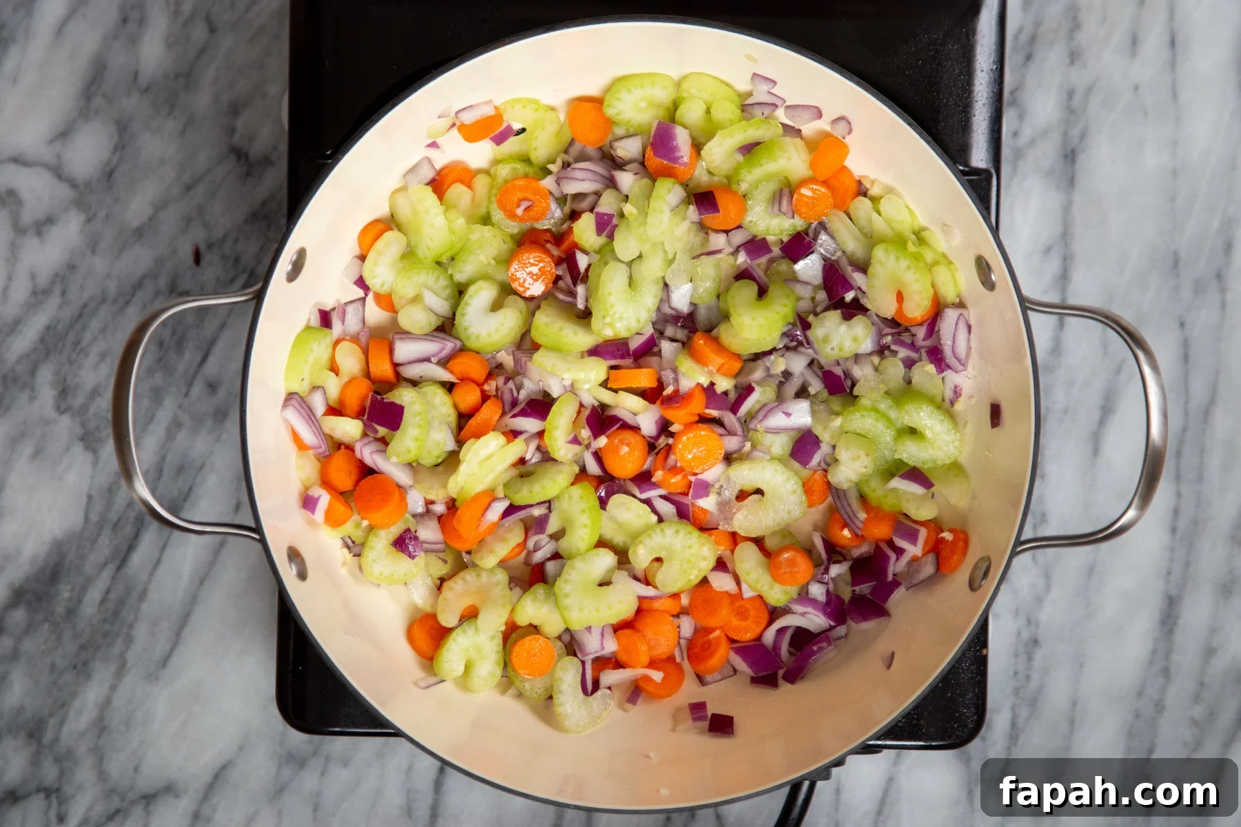 carrots, onions and celery in a sauteeing pan 