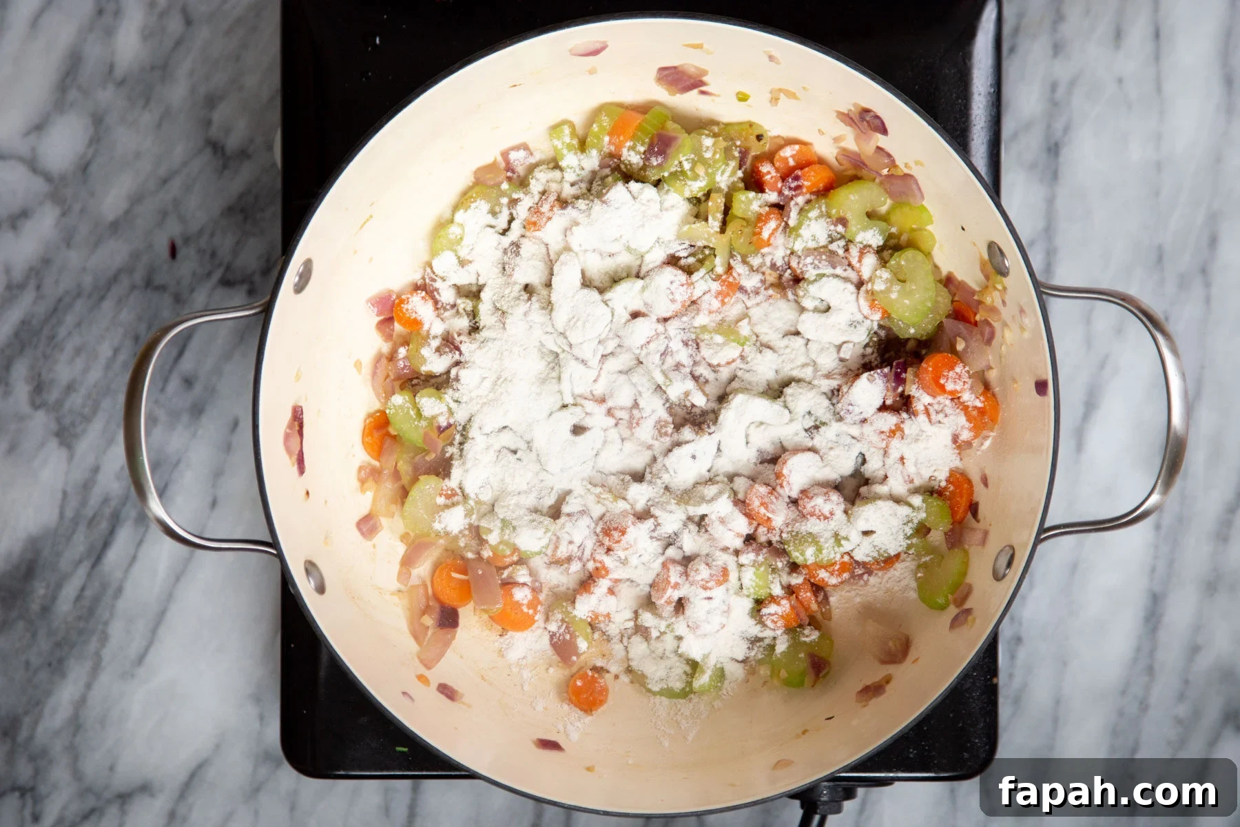 veggies and cornstarch in a saucepan on a cooking plate 
