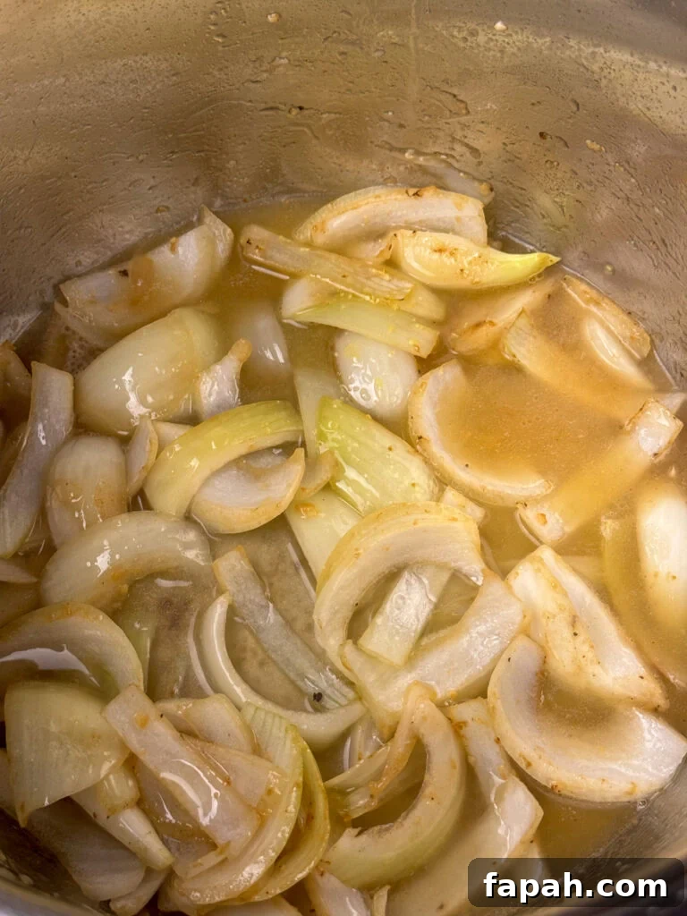 Chicken broth poured over top of tender slices of onions and browned minced garlic.
