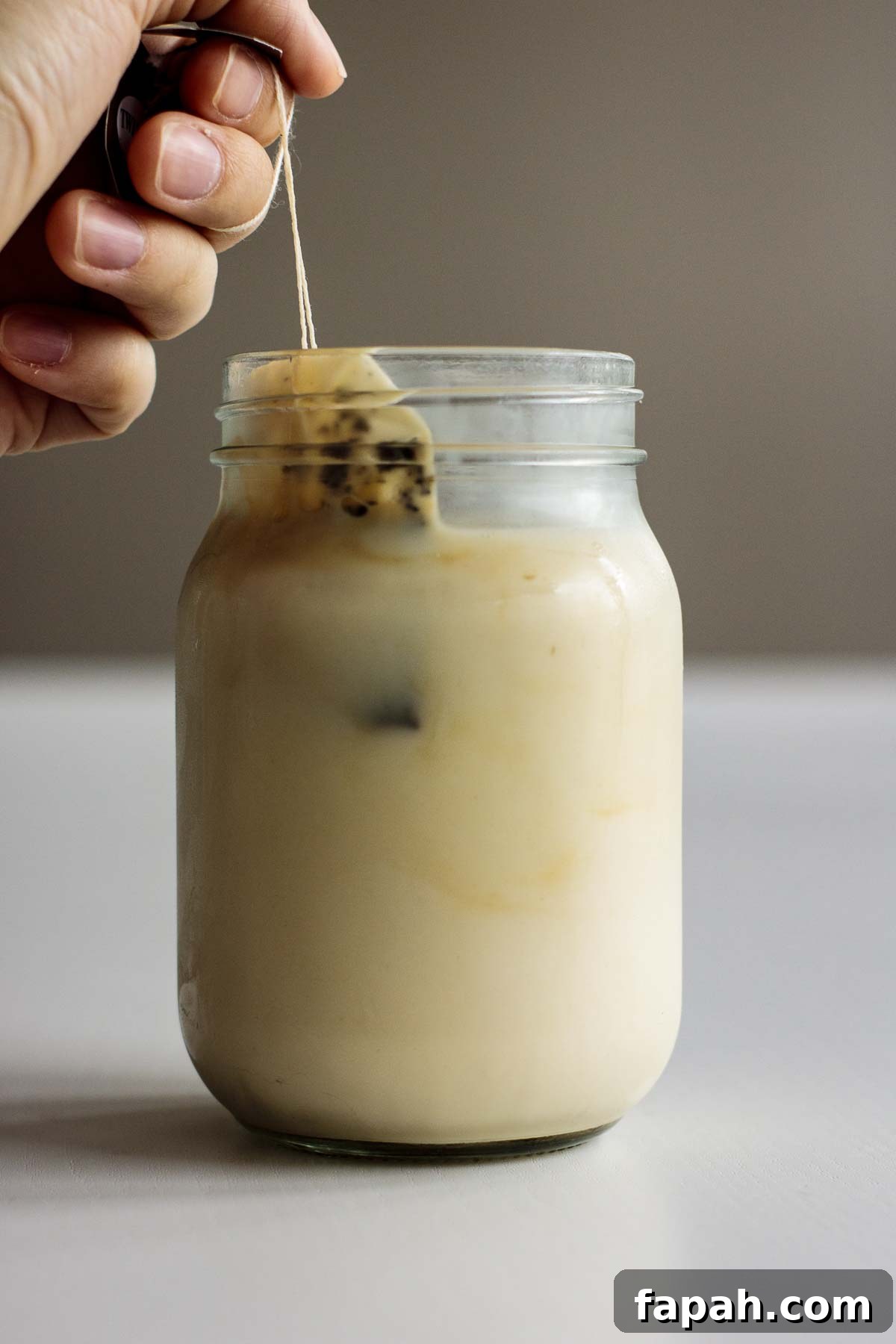 Tea bags being removed from cold brew milk tea.