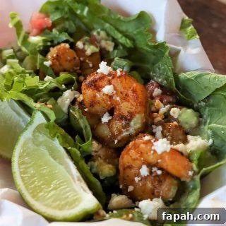 Feature image with a closeup of shrimp served in lettuce and garnished with a wedge of lime, cheese, and dressing