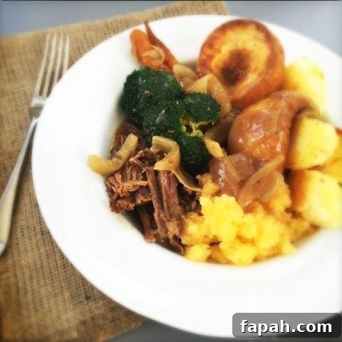 hessian table cloth with white plate loaded with pulled brisket, roast potatoes, yorkshire pudding, mashed swede and broccoli