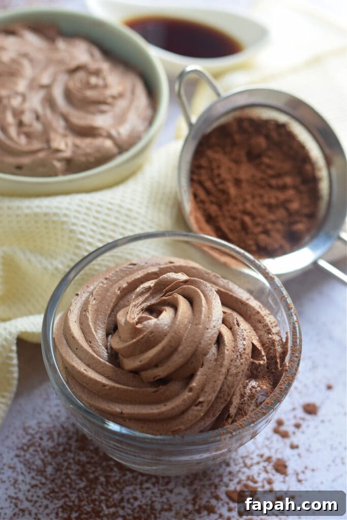 Close up of chocolate frosting in a glass bowl.