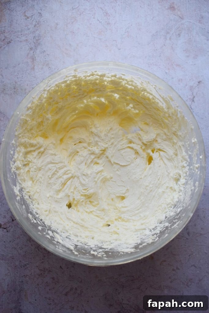 Making buttercream frosting in a glass bowl.