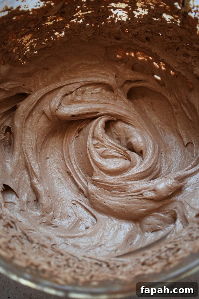 Chocolate buttercream frosting in a glass bowl.