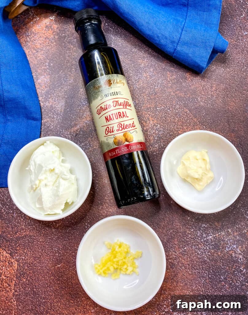bottle of truffle oil, and containers of Greek yogurt, garlic, and mayo on a flat surface