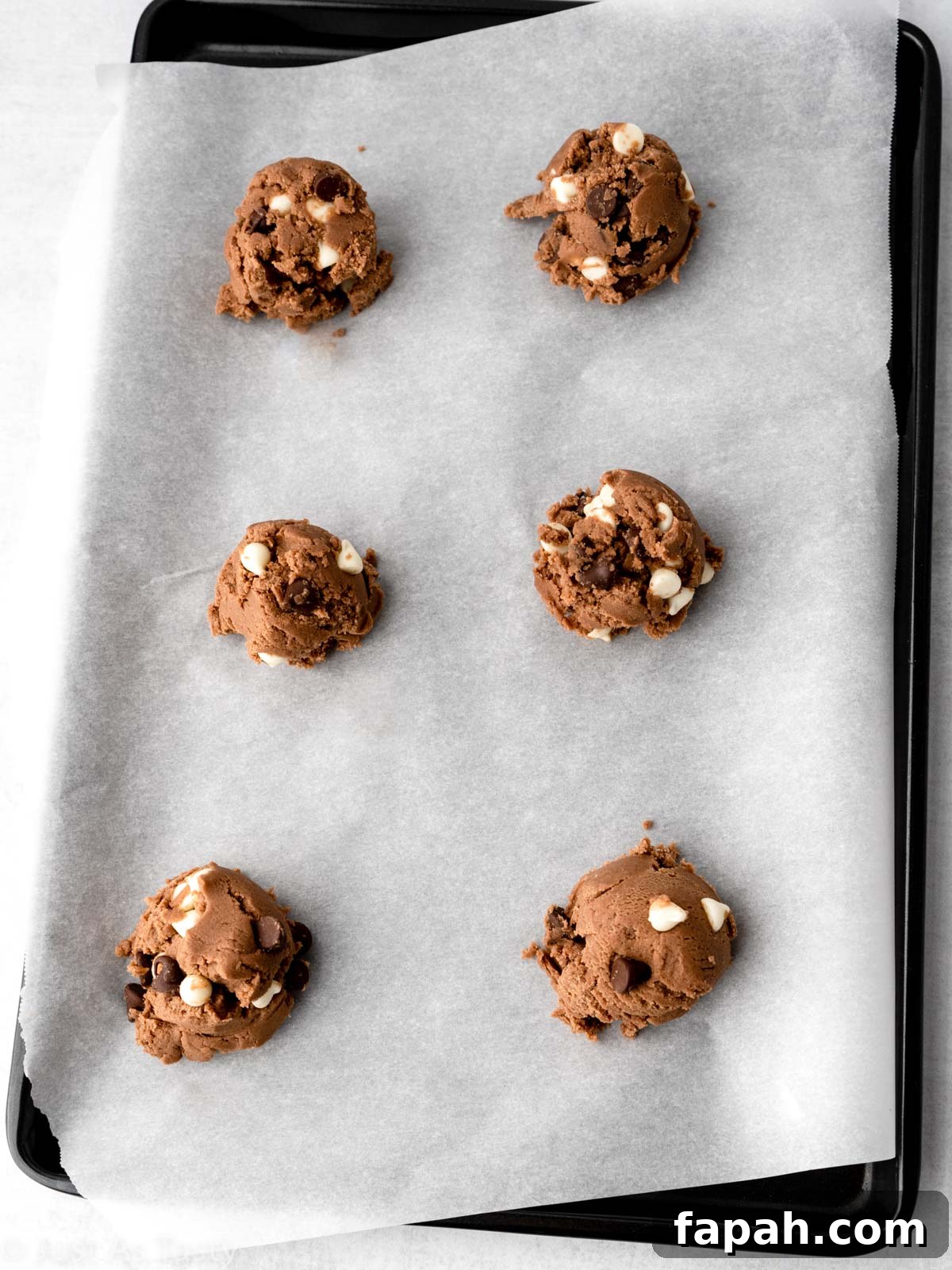Triple Chocolate Chip Cookies — Gluten-Free Recipe 9 Scoops of cookie dough on a baking sheet.