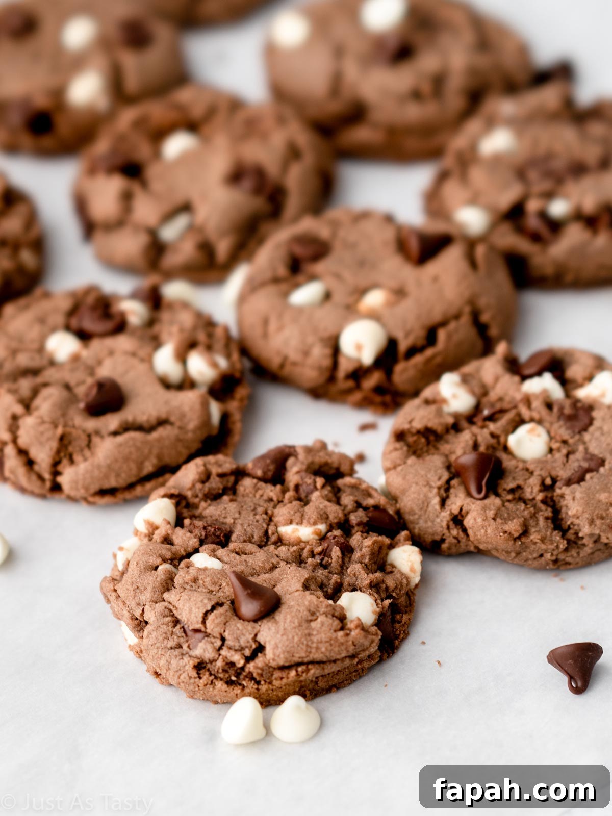 Triple Chocolate Chip Cookies — Gluten-Free Recipe 10 Triple chocolate chip cookies on parchment paper.