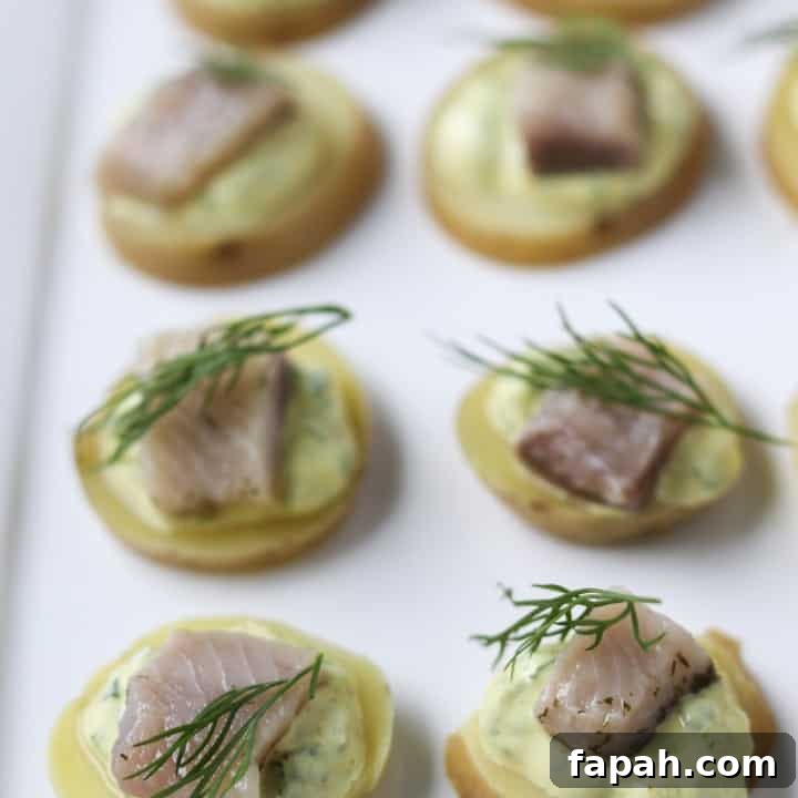 A close up of pickled herring bites topped with dill