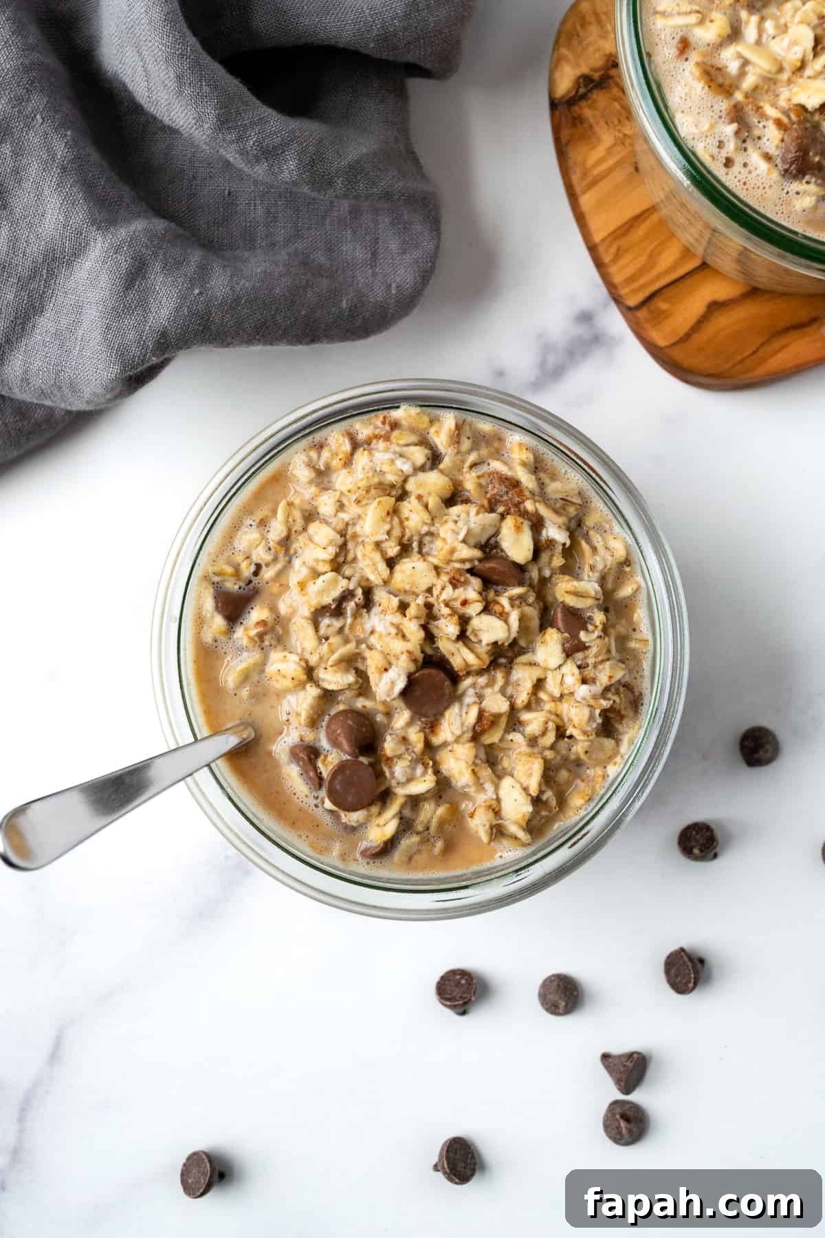 Cookie Dough Overnight Oats in a glass jar with a spoon.
