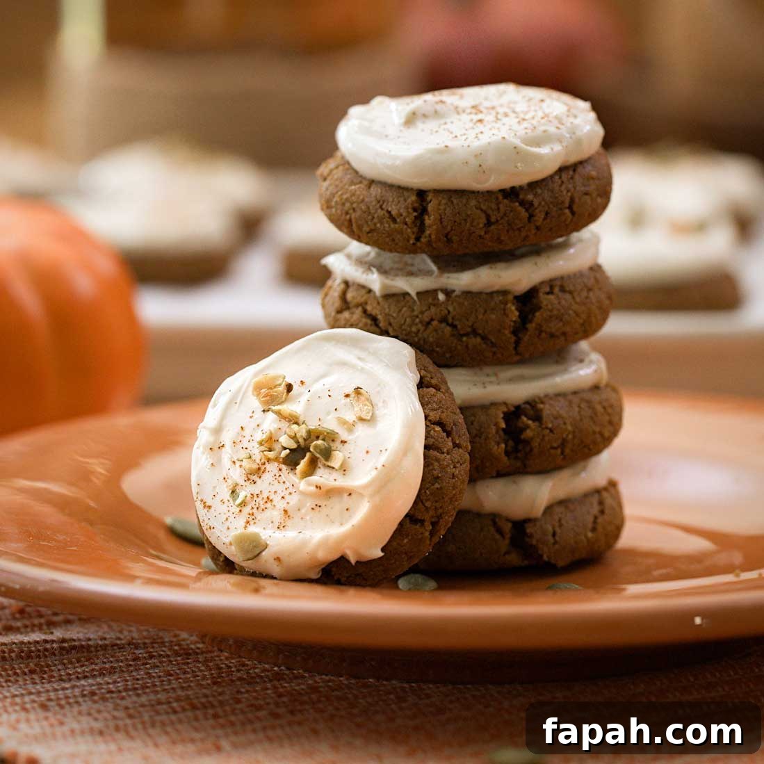 A stack of cream cheese pumpkin cookies on an orange plate.