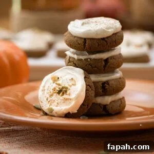 A stack of cream cheese pumpkin cookies on an orange plate.